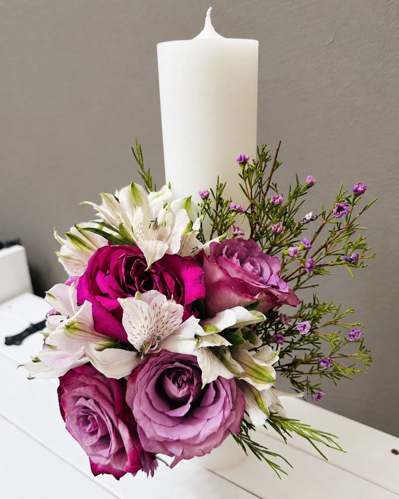 Lumânare albă cu trandafiri mov și fucsia, alstroemeria albă și ramuri fine cu flori mici lila